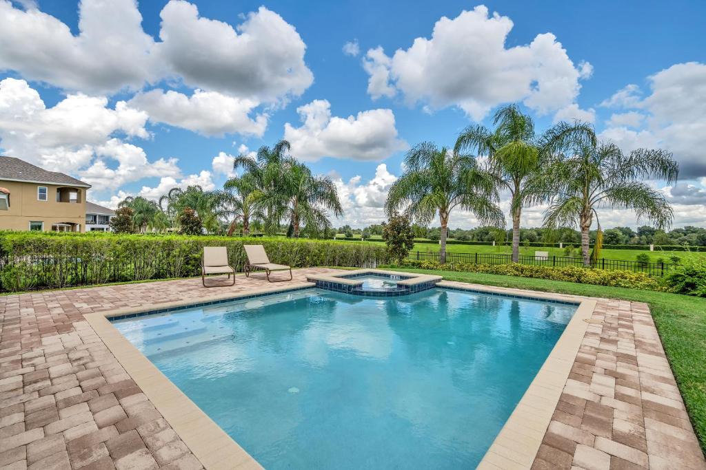 uma piscina com duas cadeiras num quintal em Modern Villa wPrivate Pool and Air Hockey Table em Orlando