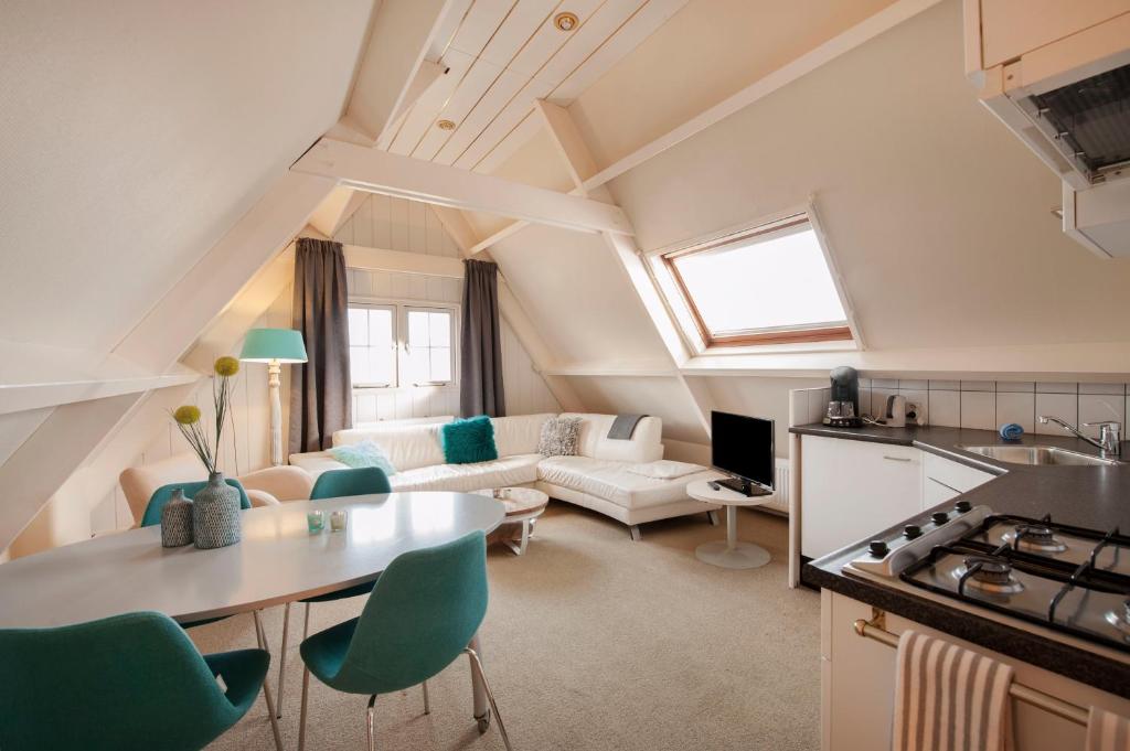uma cozinha e sala de estar com um sofá e uma mesa em Appartement Parkweg em Bergen aan Zee