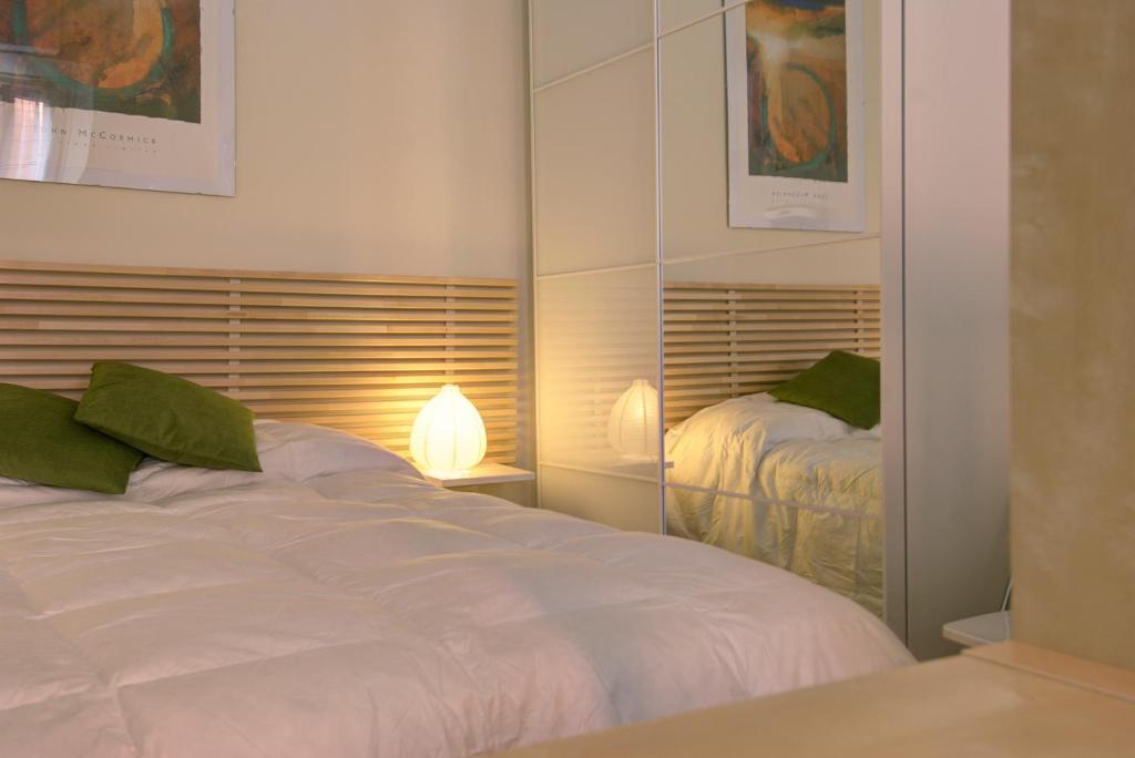 ボローニャにあるUR-NEST Corte Galluzziのベッドルーム(白いベッド1台、鏡付)