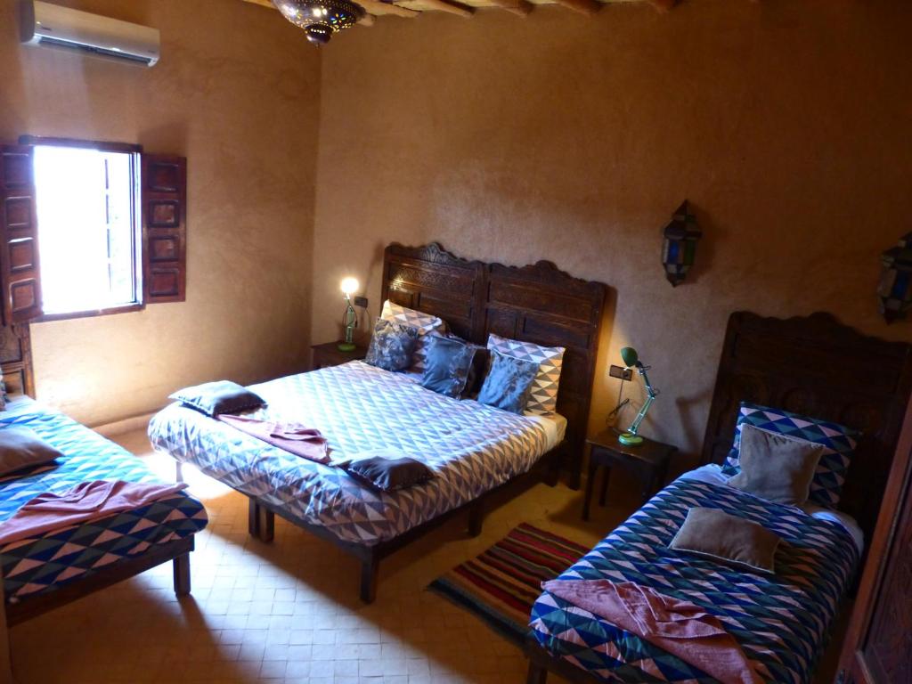 a bedroom with two beds and a couch in it at Riad Caravasar in Merzouga