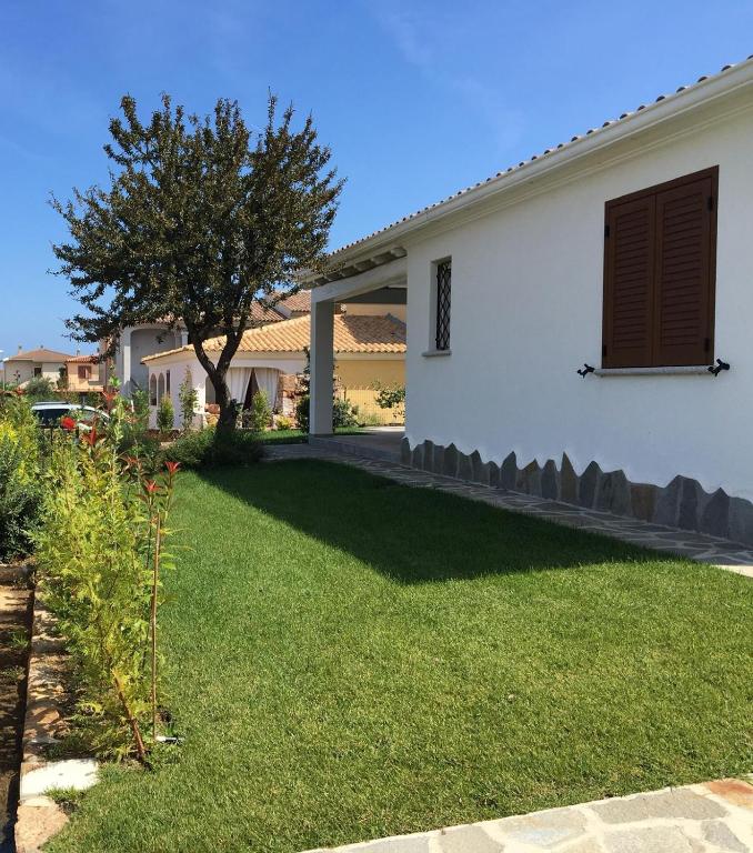 a house with a yard with green grass and a tree at Perla in Budoni