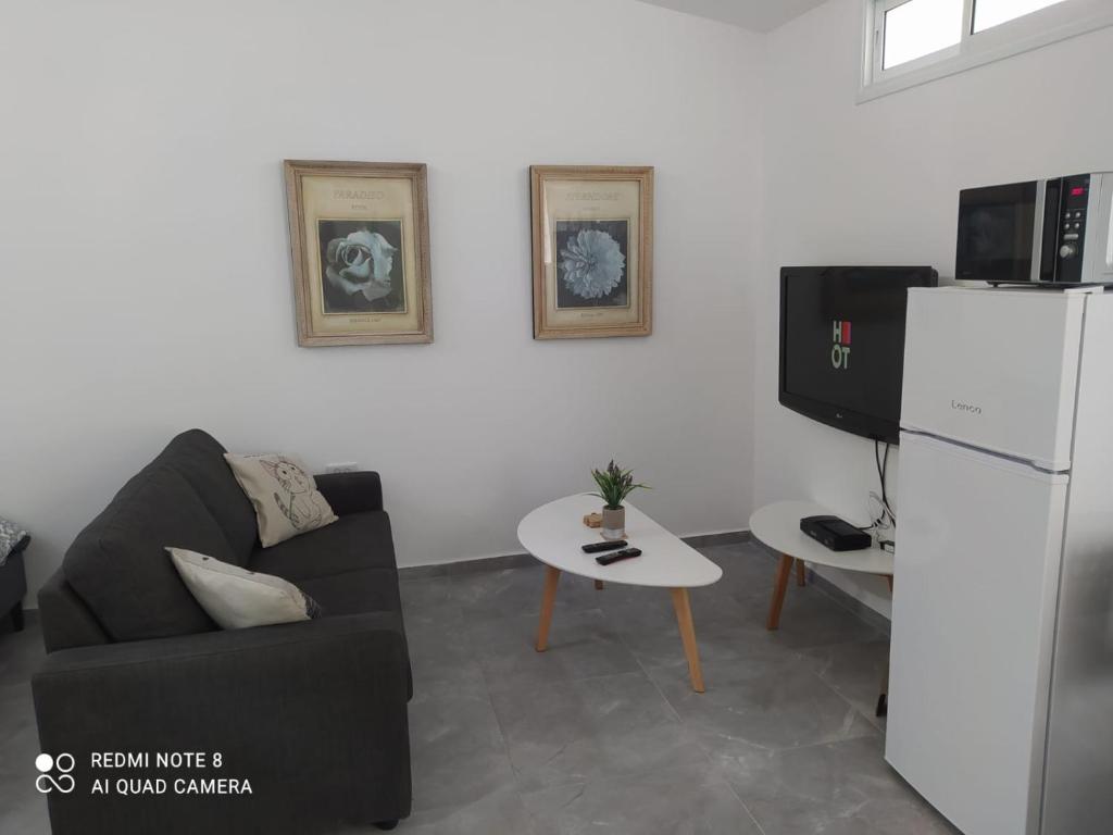 un soggiorno con divano e frigorifero di Eilat vacation studio סטודיו נופש באילת a Eilat