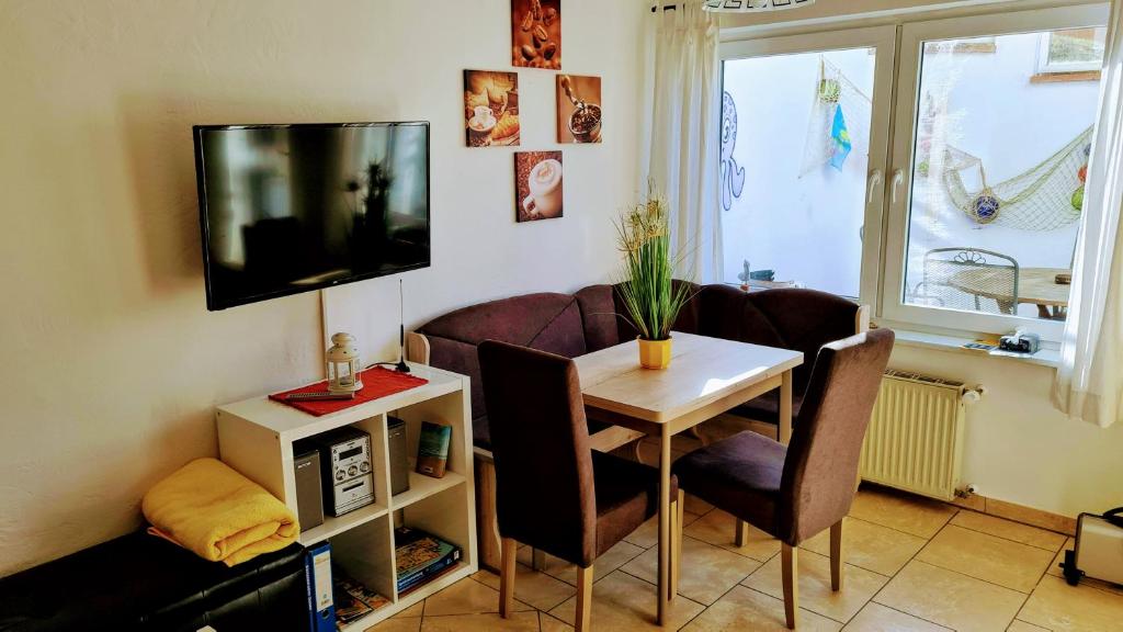 - un salon avec une table et une télévision dans l'établissement Apartment Tintenfisch Strandkorb inkl, à Göhren