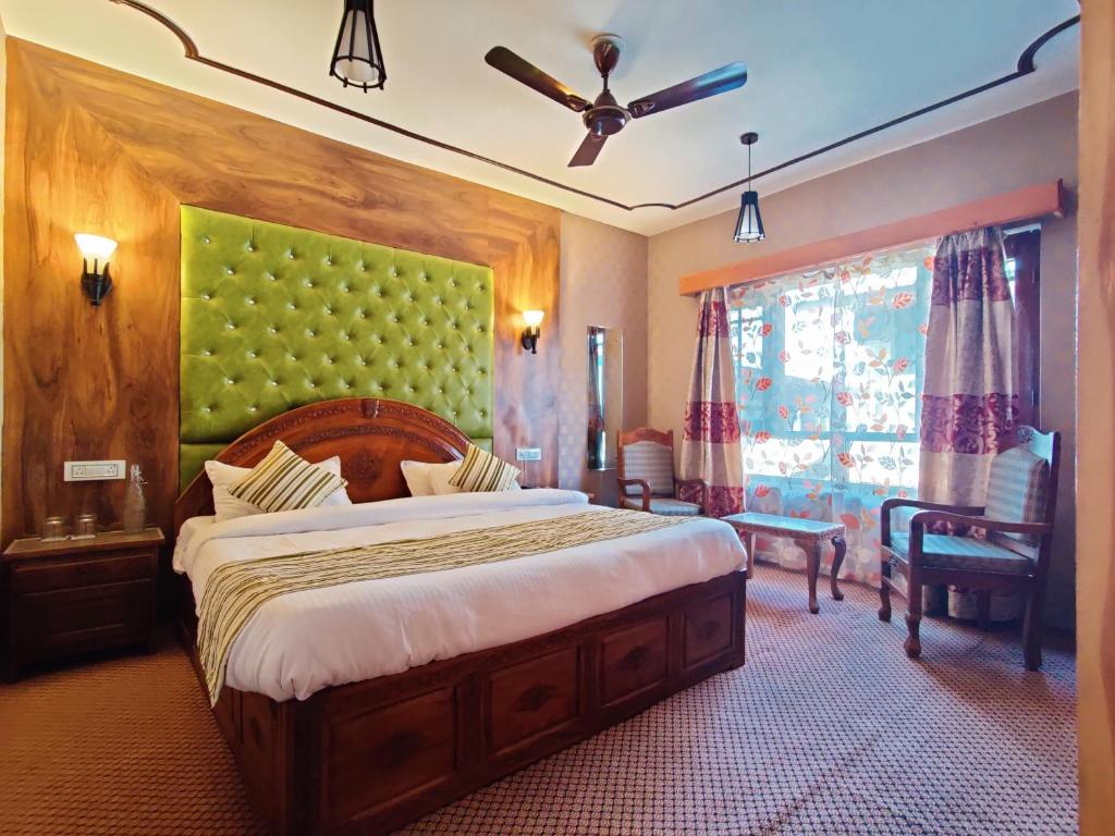 1 dormitorio con 1 cama grande y cabecero verde en The Shelter Heritage A Boutique Hotel, en Srinagar