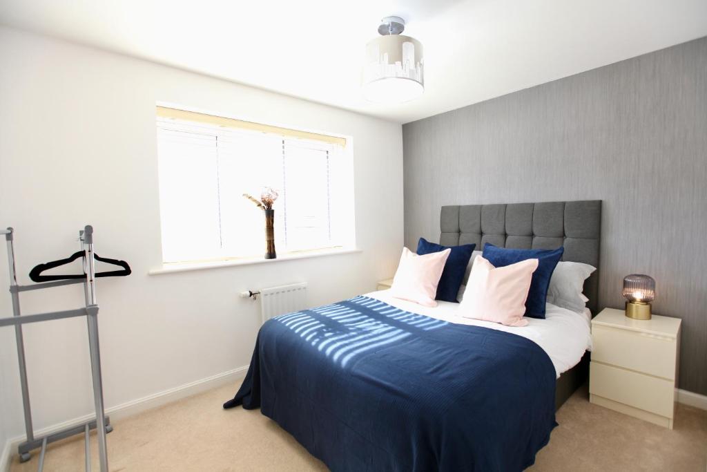 1 dormitorio con cama con sábanas azules y ventana en Large Stylish Cambridge House (4BR/Free Parking) en Cambridge