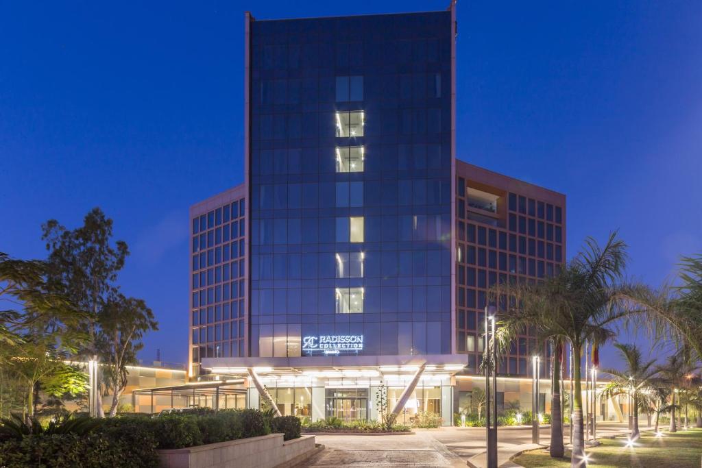 un edificio alto con un cartel en él por la noche en Radisson Collection Hotel Bamako, en Bamako