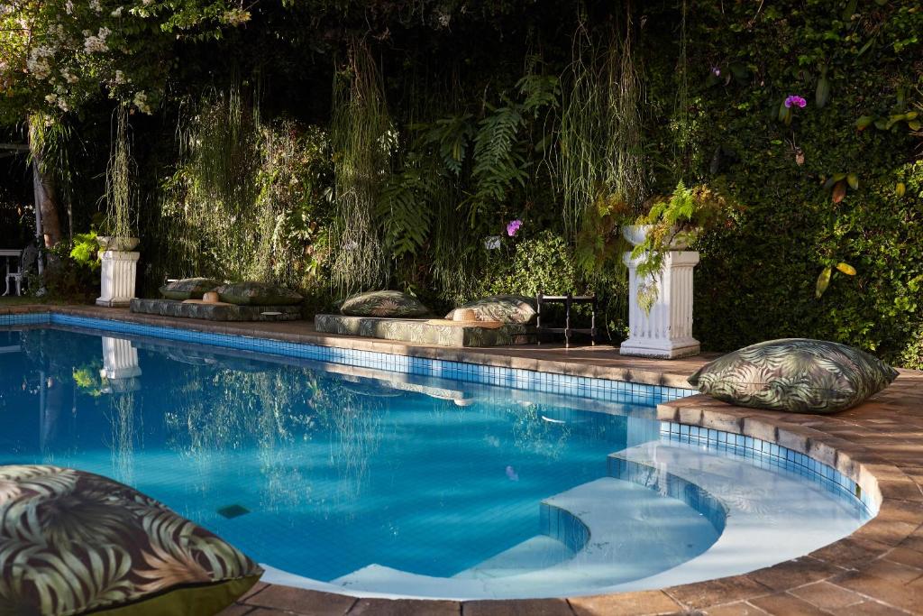 uma piscina com almofadas num quintal em Mama Ruisa Boutique Hotel no Rio de Janeiro