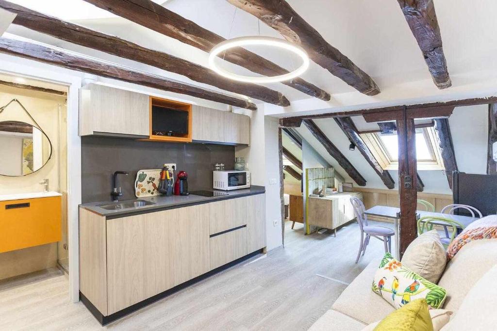 uma cozinha e uma sala de estar com um sofá e uma kitchenette em Apartamento lujo fuencarral chueca em Madri
