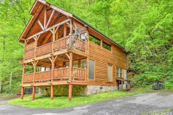 a large wooden house in the middle of a forest at Smokey Max Cabin in Pigeon Forge