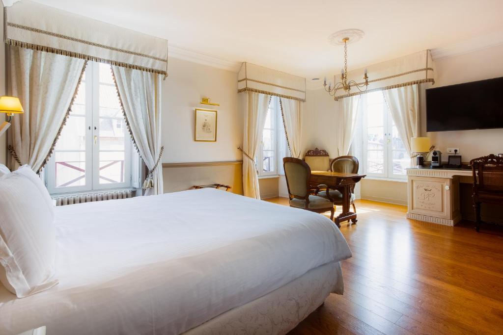 une chambre avec un grand lit blanc et un bureau dans l'établissement Mercure Moulins Centre Hôtel de Paris, à Moulins