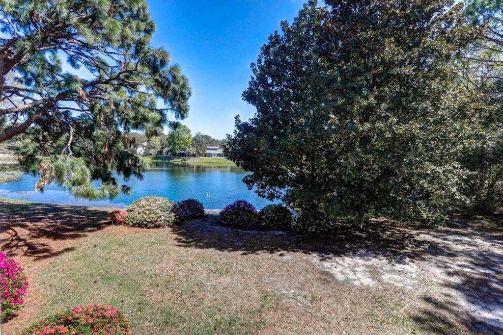 a view of a lake with trees and flowers at Lakeside 312 at Bluewater Bay Resort in Niceville