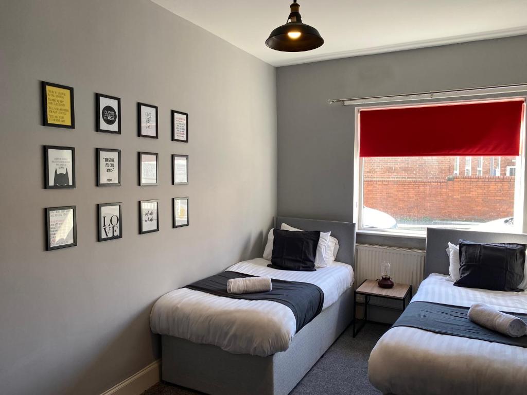 1 dormitorio con 2 camas individuales y ventana en Luke Stays - Rokeby Street, en Newcastle