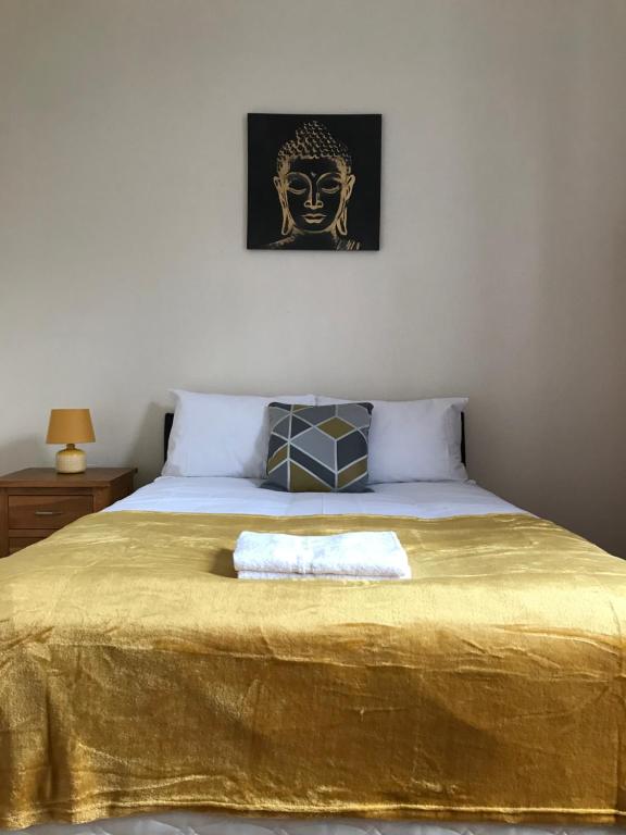 een slaapkamer met een bed met een gouden deken erop bij Apex Haymarket Station Apartment in Edinburgh