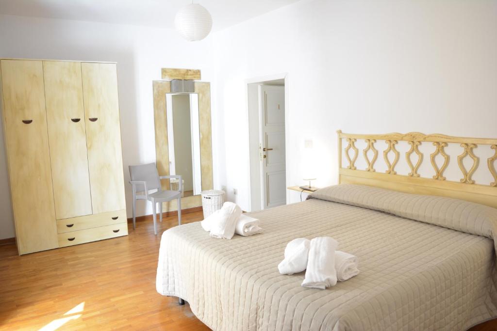 - une chambre avec un lit et des serviettes dans l'établissement OLASPRI, à Oschiri