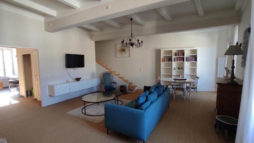 Montcuq的住宿－La Montcuquoise，客厅配有蓝色的沙发和桌子