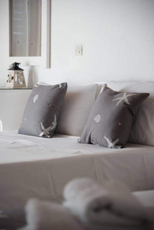 a white couch with two pillows on it at Fisilanis Beachfront Hotel in Logaras