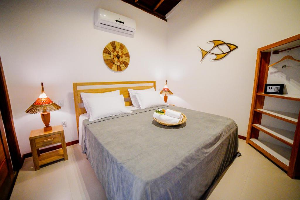 een slaapkamer met een bed met een kom erop bij Carapitangui Pousada in Barra Grande