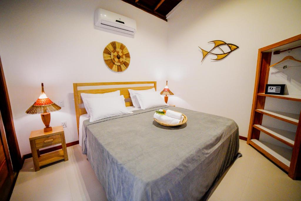 a bedroom with a bed with a bowl on it at Carapitangui Pousada in Barra Grande