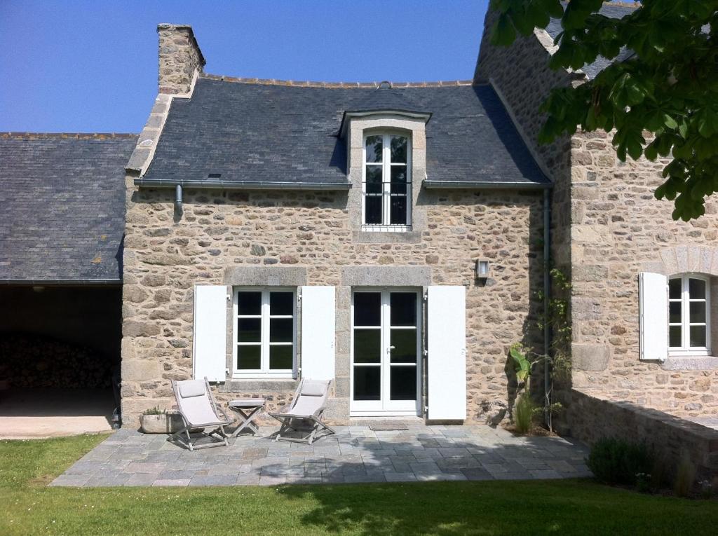 聖呂奈爾的住宿－Le Petit Tertre - charmante maison entre terre et mer - St Lunaire，石头房子前面的两把椅子和一张桌子