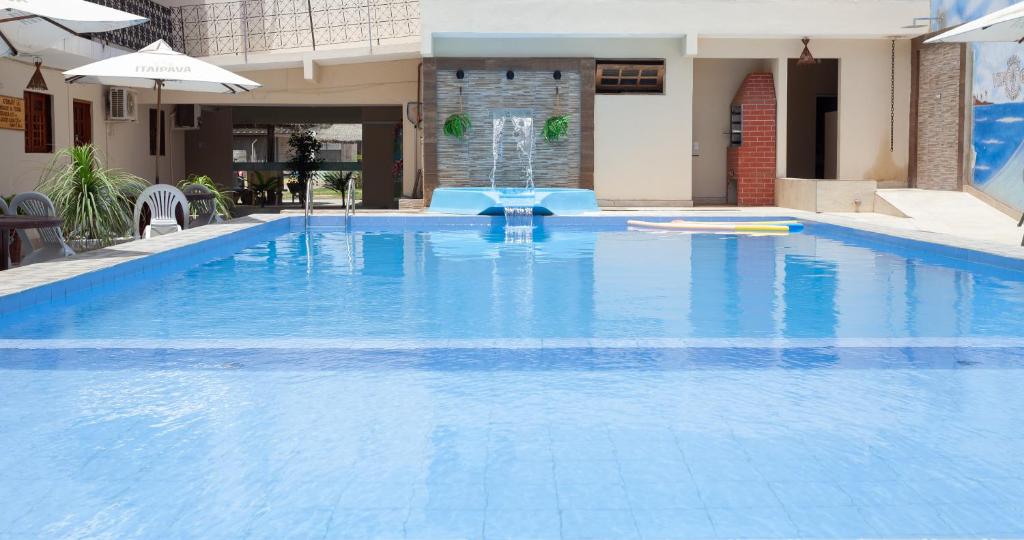 a large blue swimming pool with a fountain at Pousada Villa Goyá in São José da Coroa Grande
