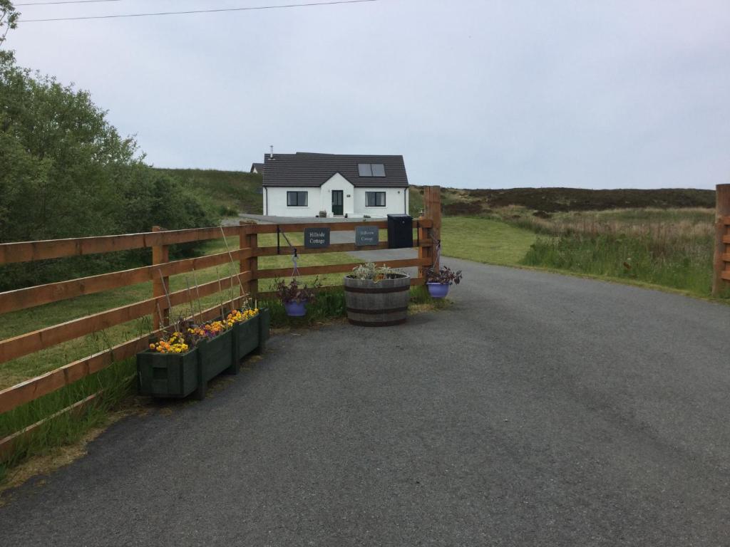 una casa al lado de una carretera con una valla en Hillside en Dunvegan