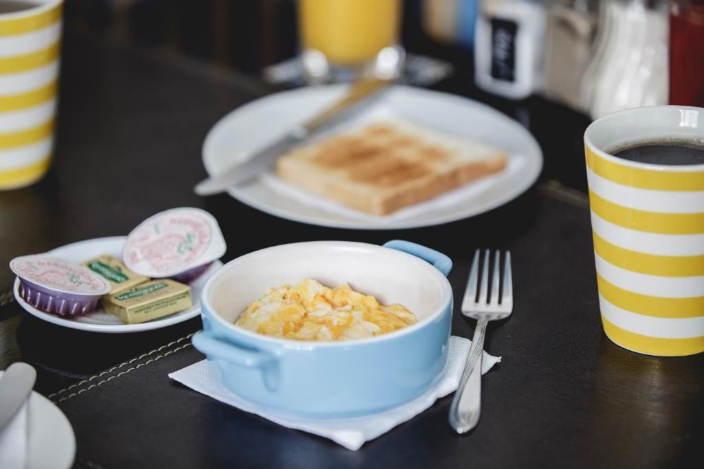 a table with a bowl of cereal and toast and a cup of coffee at Hostal Ventisqueros in Punta Arenas