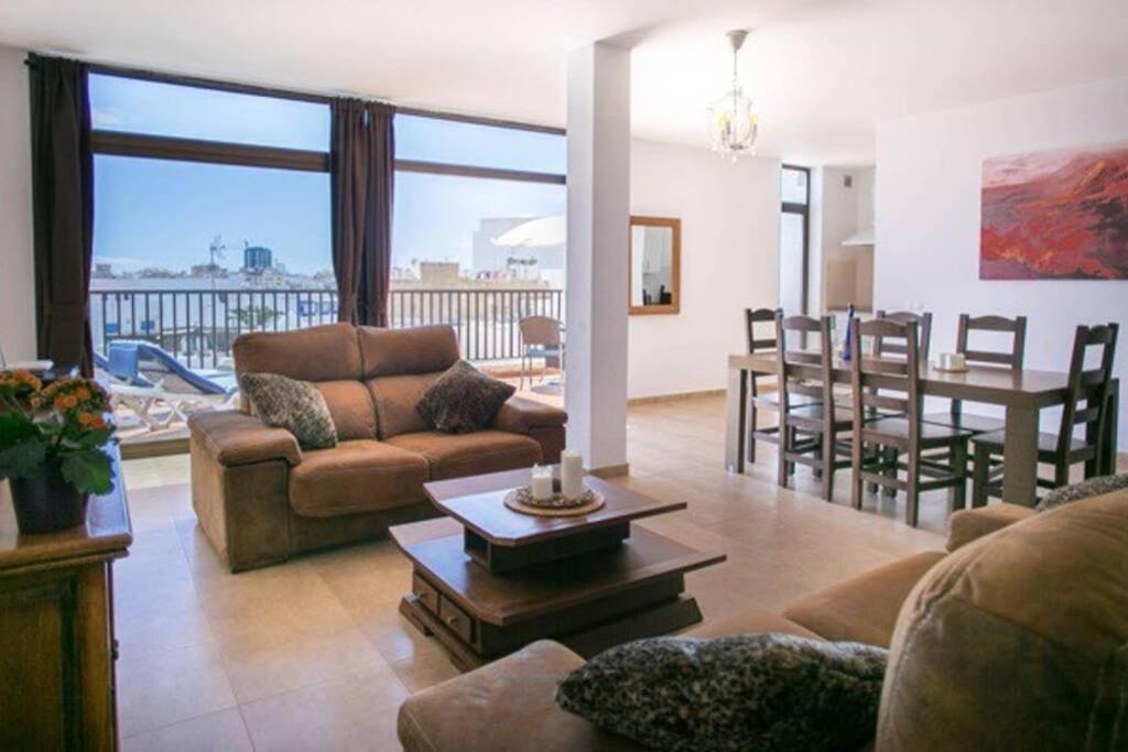 una sala de estar con un sofá y una mesa en The Penthouse Ascona in El Charco, en Arrecife
