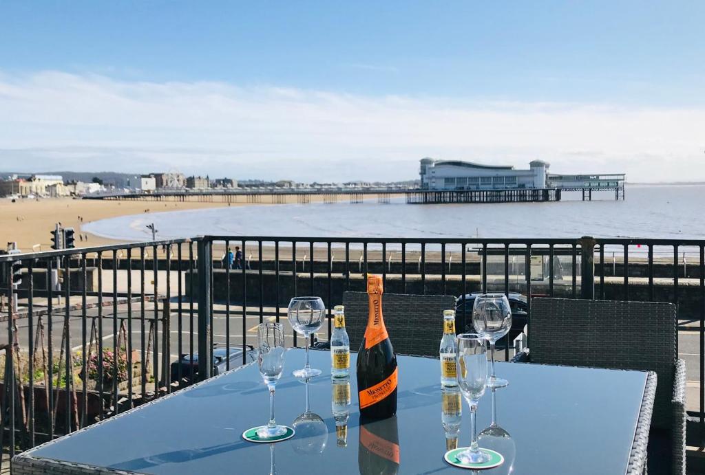 einen Tisch mit Gläsern und eine Flasche Wein am Strand in der Unterkunft Pavilion Holiday Apartments in Weston-super-Mare