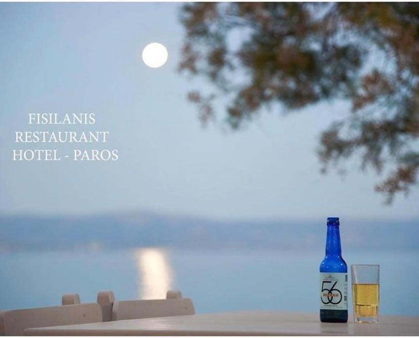 a bottle of wine and two glasses on a table at Fisilanis Beachfront Hotel in Logaras