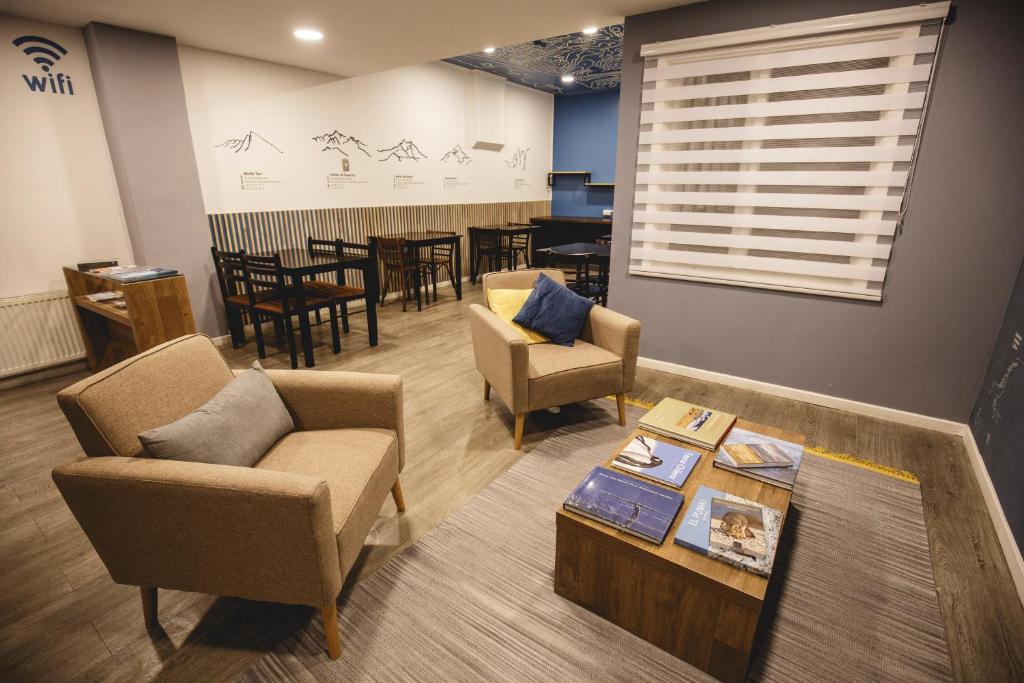uma sala de espera com cadeiras e uma mesa e uma sala de jantar em Hostal Ventisqueros em Punta Arenas