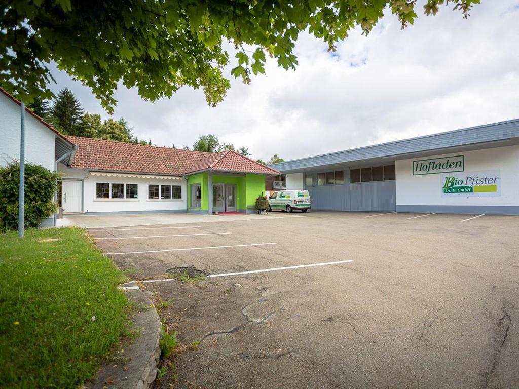 un edificio con un coche aparcado en un aparcamiento en Bio Pfister Trade GmbH, en Burladingen