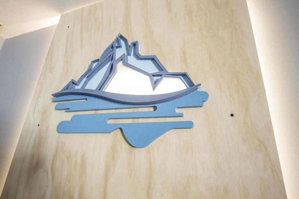 a sign on a wooden wall with a mountain at Hostal Ventisqueros in Punta Arenas