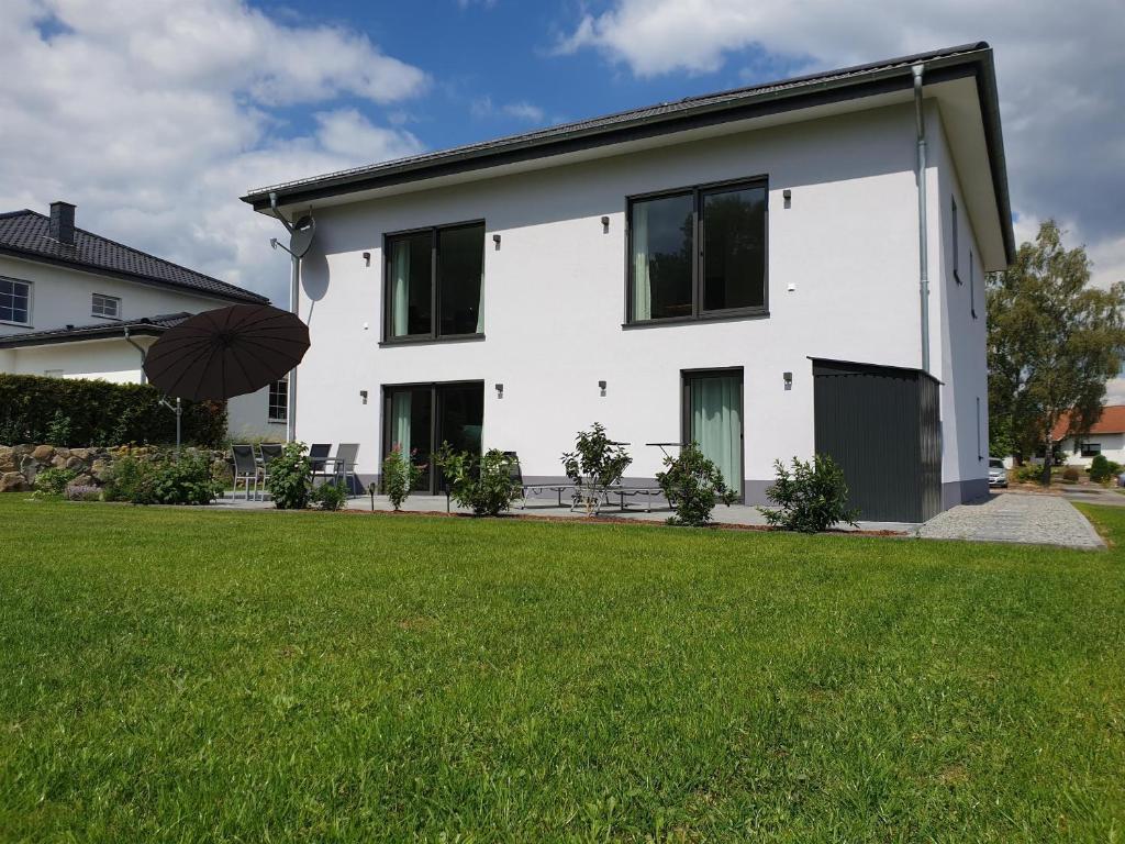 a white house with a lawn in front of it at Ferienhaus Dreier-Ley in Üdersdorf