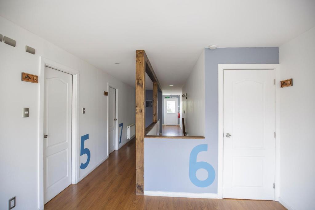 a hallway with a mirror in a room with white walls at Hostal Ventisqueros in Punta Arenas