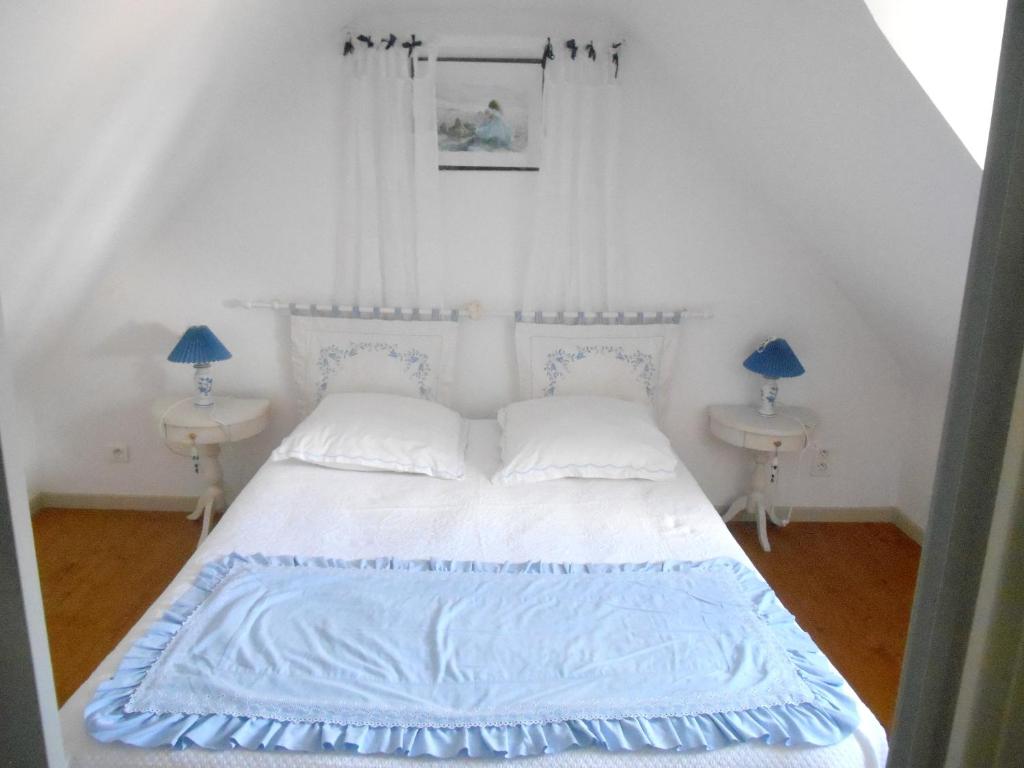 - une chambre dotée d'un lit blanc avec des draps bleus et 2 lampes dans l'établissement Maison de 2 chambres avec jardin clos et wifi a Cleden Cap Sizun a 4 km de la plage, à Cléden-Cap-Sizun
