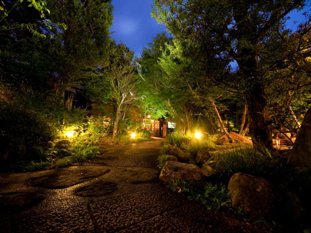 un jardín de noche con árboles y luces en Hatago Kounokura, en Yufu