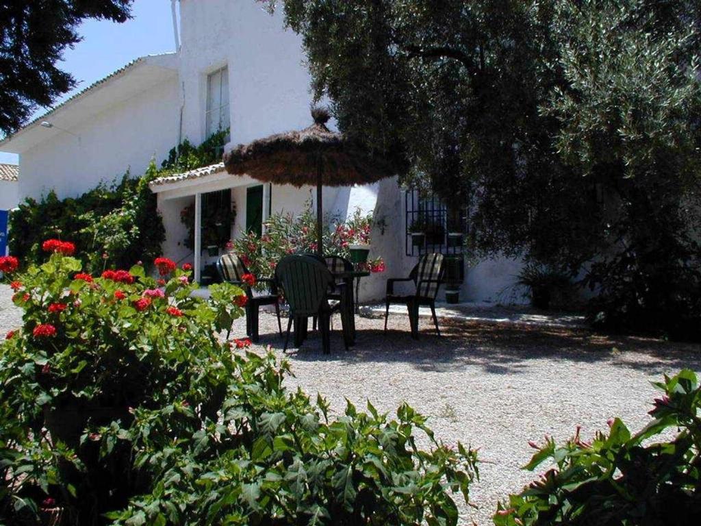 une terrasse avec une table, des chaises et un parasol dans l'établissement Casa Rural La Cateta, à Mancha Real