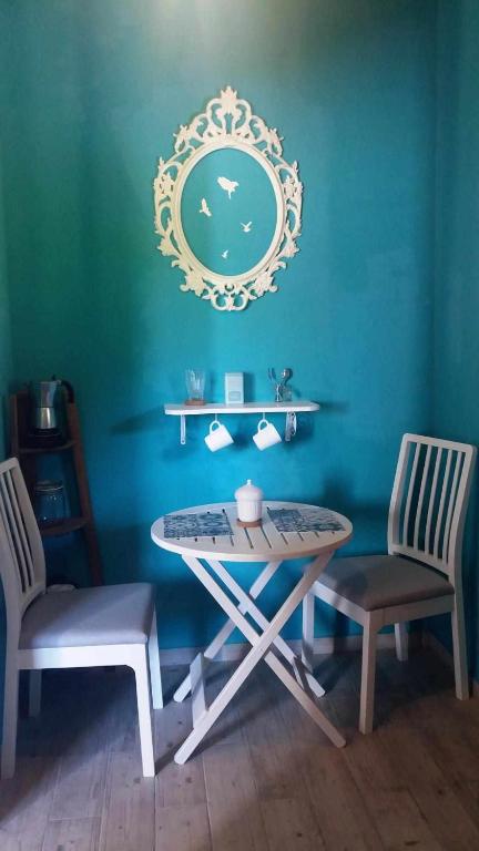 una mesa y sillas en una habitación con una pared azul en Habitacion dormitorio rural itaka, en Zugarramurdi