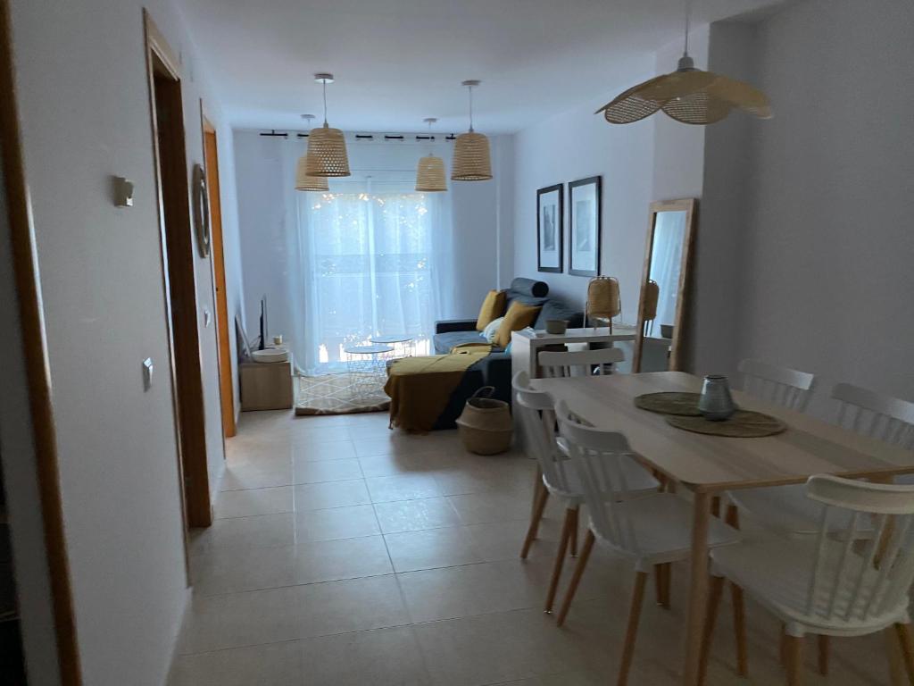 cocina y sala de estar con mesa y sillas en Funcional apartamento en Sitges