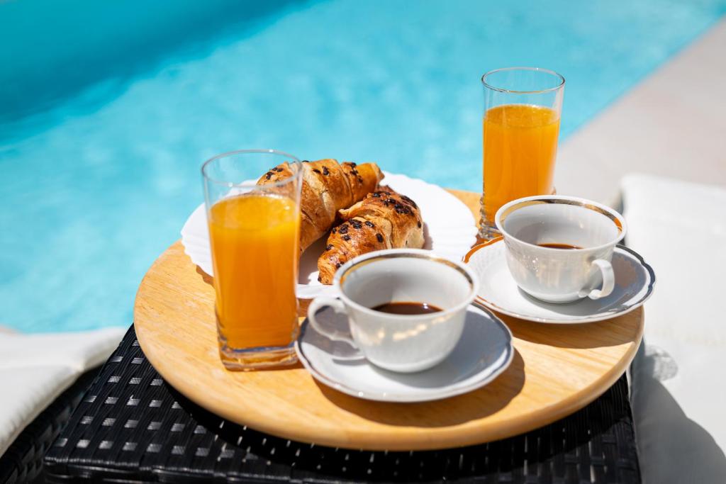a tray with coffee and croissants and two glasses of orange juice at Entire private top floor with own pool and entrance in Primošten