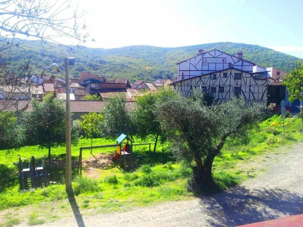 een uitzicht op een dorp met een boom en een huis bij Casa Rural FranciaQuilamas in Santibáñez de la Sierra