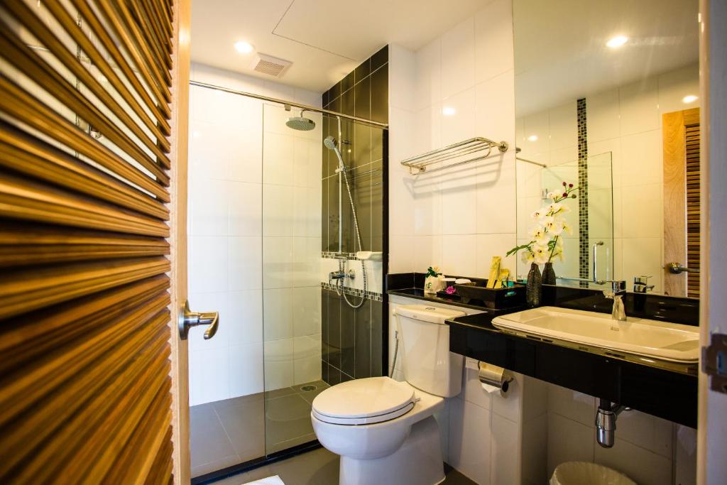 uma casa de banho com um WC, um lavatório e um chuveiro em Crystal Jade Hotel em Rayong