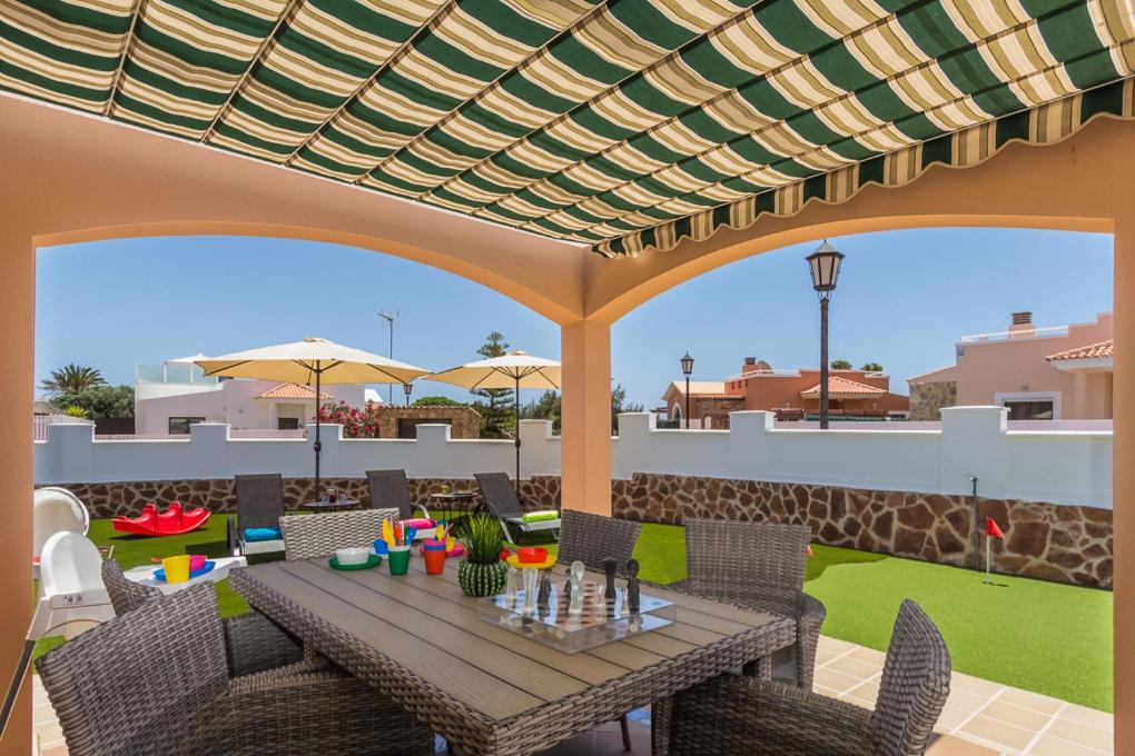 eine Terrasse mit einem Holztisch, Stühlen und einem Dach in der Unterkunft Perfect for family holidays with private pool, near beach and golf- Villa Ashley in Costa de Antigua