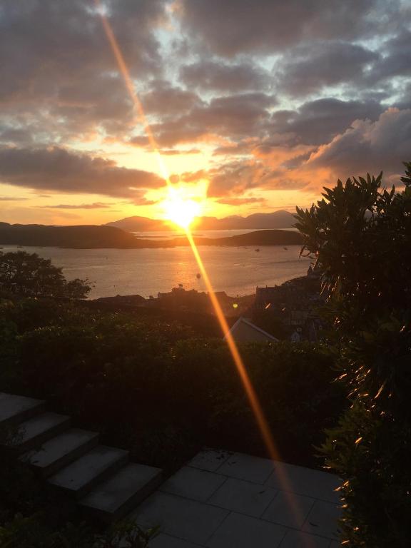 a sunset with the sun setting over the water at Tigh Beag in Oban