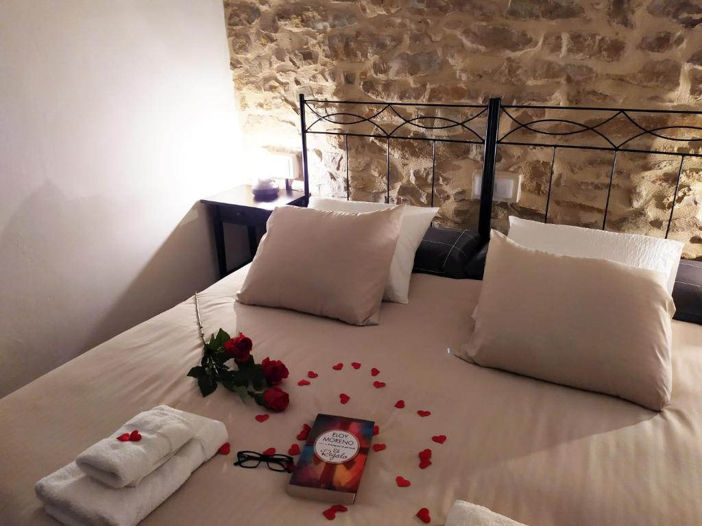 Una cama con pedales de rosa roja. en Apartamentos Xert Escapadas en Castellón Cerca de Morella y Peñíscola, en Chert