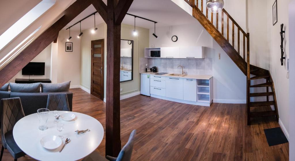 a kitchen and a living room with a table and chairs at Old Bridge View in Toruń