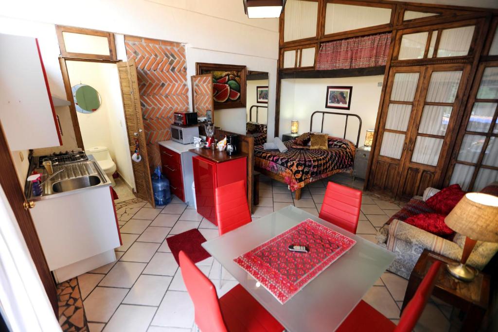 a kitchen with a table and red chairs in a room at Majikal B&B - Jacaranda in Cholula