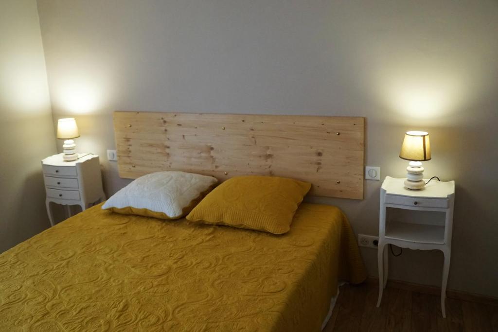 1 dormitorio con 1 cama con 2 mesitas de noche y 2 lámparas en Lourecantou, en Saint-Thibéry