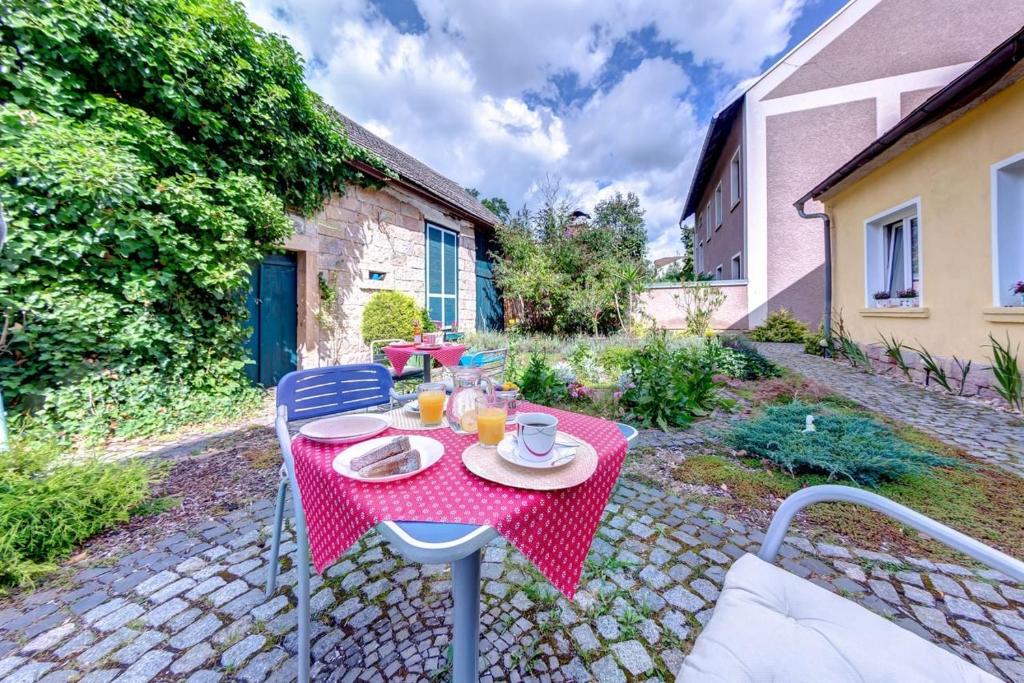 a table with a red table cloth on a patio at Penzion Petra in Lázně Bělohrad