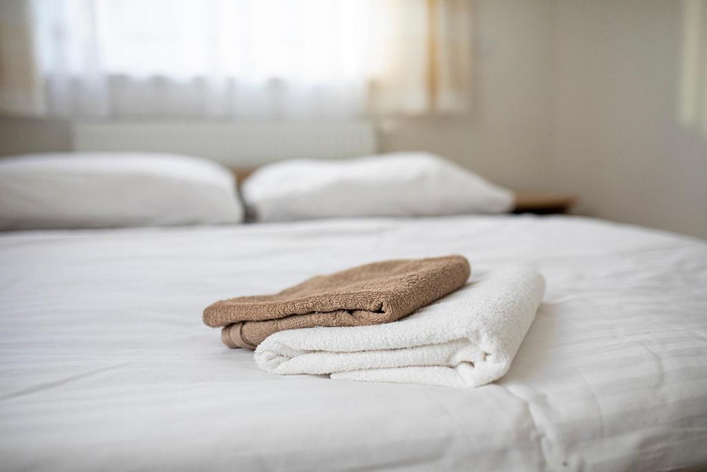 2 toallas sentadas encima de una cama blanca en Vegas Hriňová Penzión en Hriňová